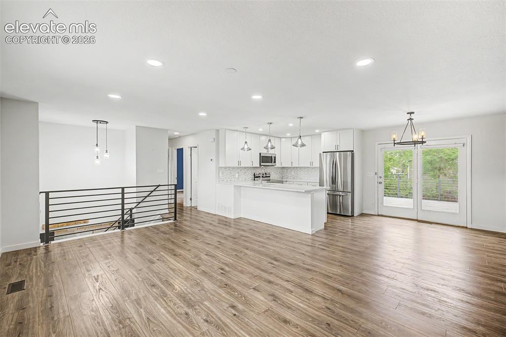 Image 3 of 44: Open-concept living space with LVP flooring, recessed lighting, and a moder