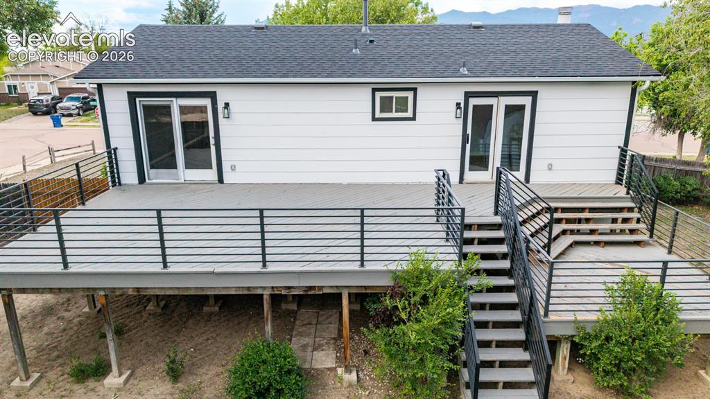 Image 31 of 44: Expansive outdoor deck featuring black metal railings, and dual exterior st