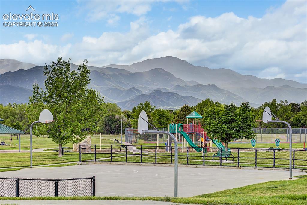Image 41 of 44: Recreational area featuring a basketball court, playground, open green spac