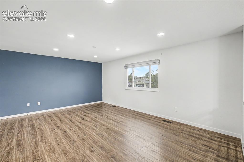 Image 5 of 44: Spacious room featuring wood-finish flooring, recessed lighting, and a prom