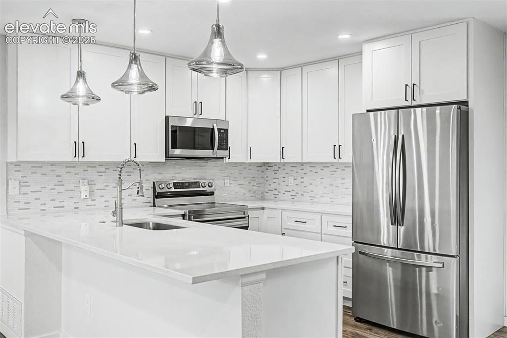 Image 8 of 44: Modern kitchen featuring white shaker cabinetry, stainless steel appliances