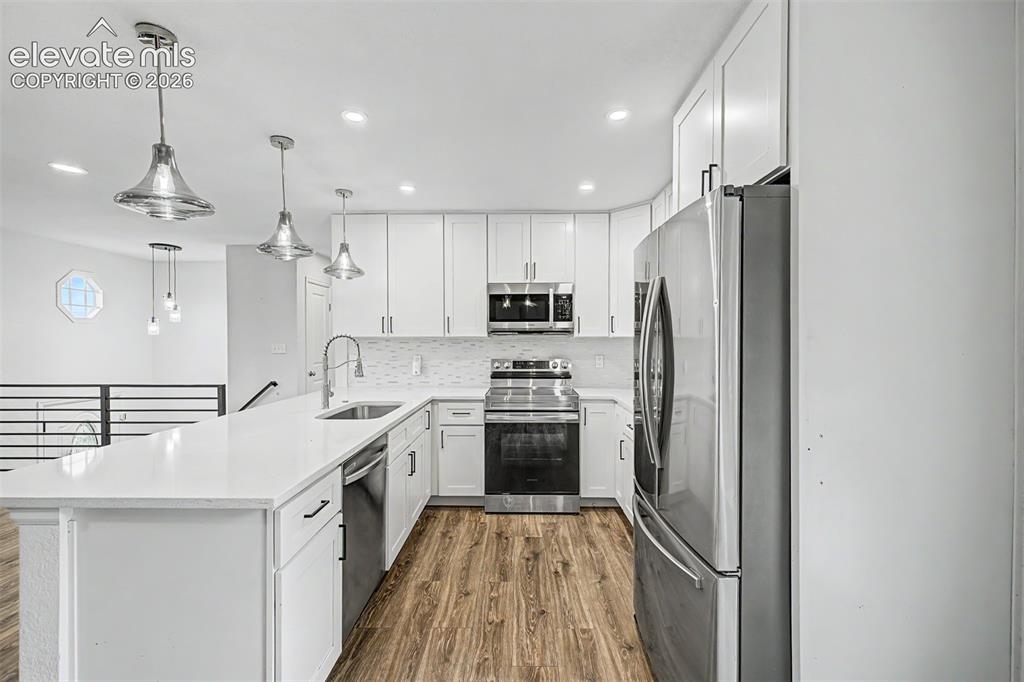Image 9 of 44: Modern kitchen featuring white cabinetry, stainless steel appliances, a whi