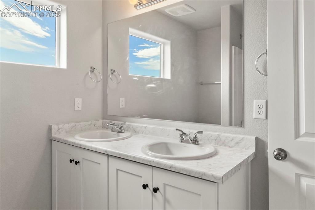 Image 15 of 22: Bathroom with double vanity and a textured wall