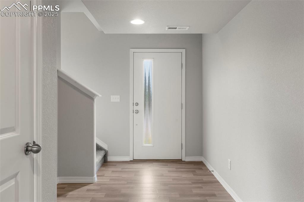 Image 3 of 22: Entryway with light wood-type flooring and stairway