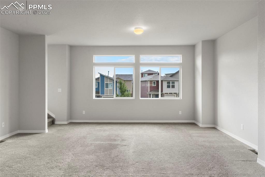 Image 6 of 22: Empty room with light colored carpet and baseboards