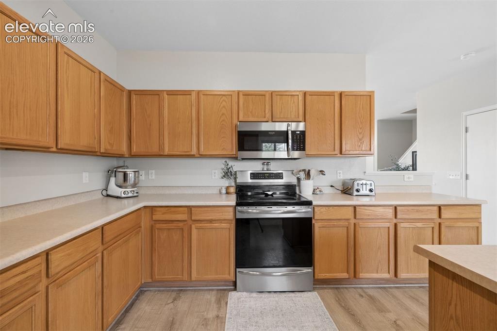 Image 7 of 43: Kitchen with electric range and built in microwave