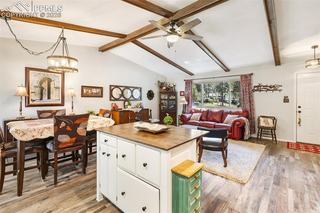 Image 25 of 36: Kitchen with hanging light fixtures, butcher block counters, open floor pla