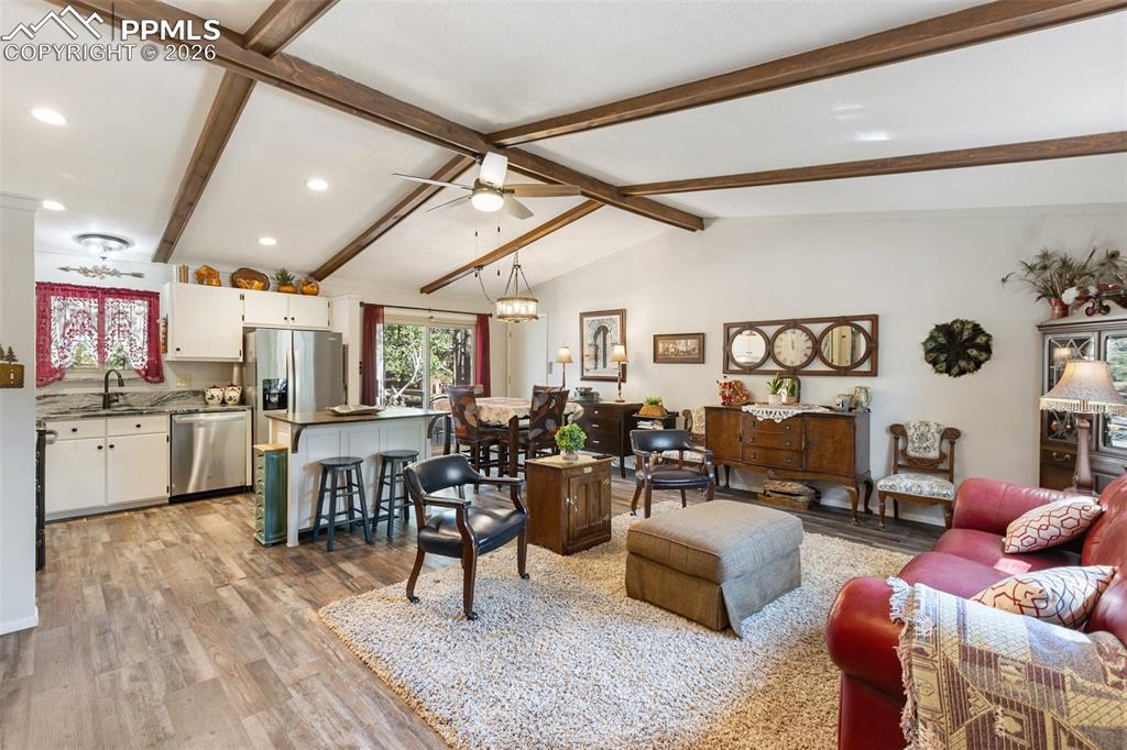 Image 32 of 36: Living area with a chandelier, light wood-style flooring, and a ceiling fan