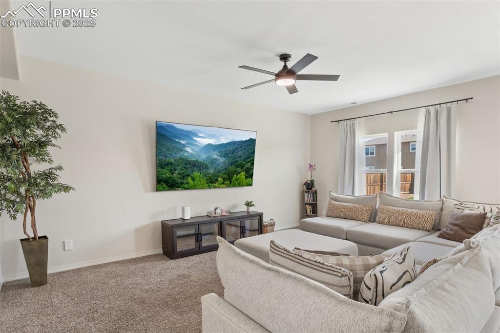 Image 7 of 25: Living room with carpet and a ceiling fan
