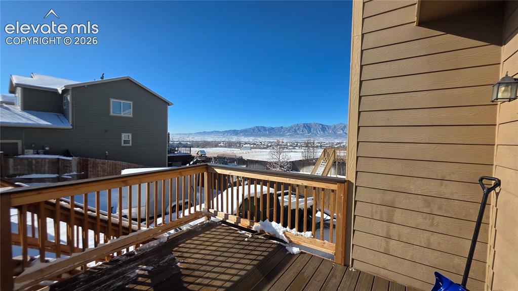 Image 16 of 35: Expansive wood-finish deck with wood railing, featuring a mountain backdrop