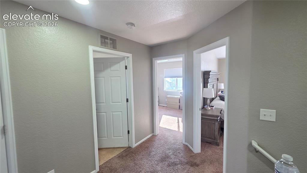 Image 17 of 35: Neutral tone walls with white trim, recessed lighting, and textured carpeti