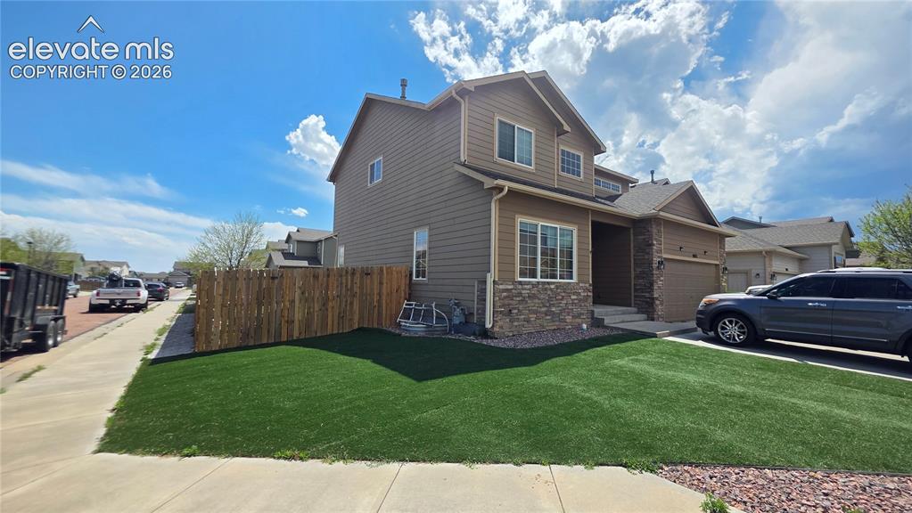 Image 2 of 35: Two-story residence featuring composite siding and stone veneer accents