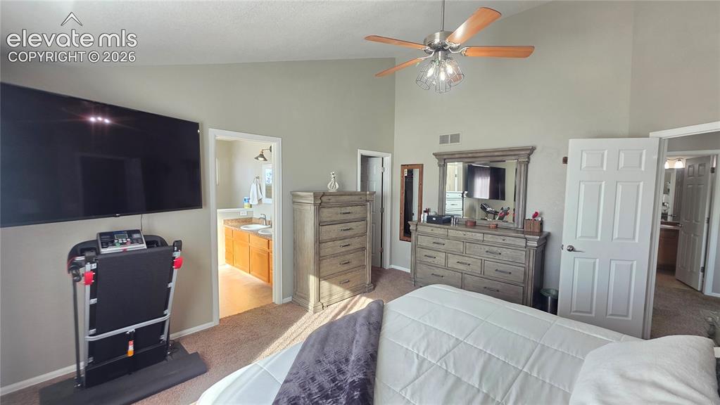 Image 22 of 35: Spacious interior room featuring vaulted ceilings, a ceiling fan with light