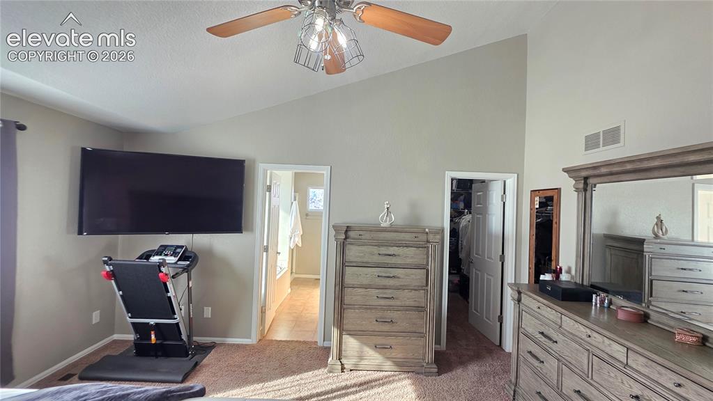 Image 23 of 35: Carpeted room with a vaulted ceiling, a ceiling fan with wood-finish blades
