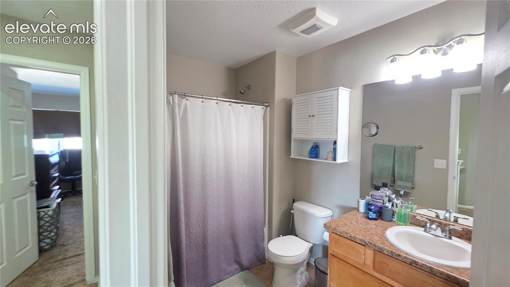 Image 28 of 35: Bathroom featuring a single vanity with an integrated sink, a light-toned c