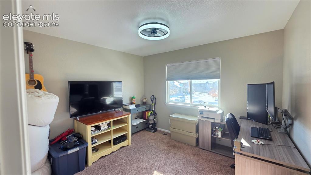 Image 29 of 35: Carpeted interior space featuring a window with blinds, ceiling fan light f