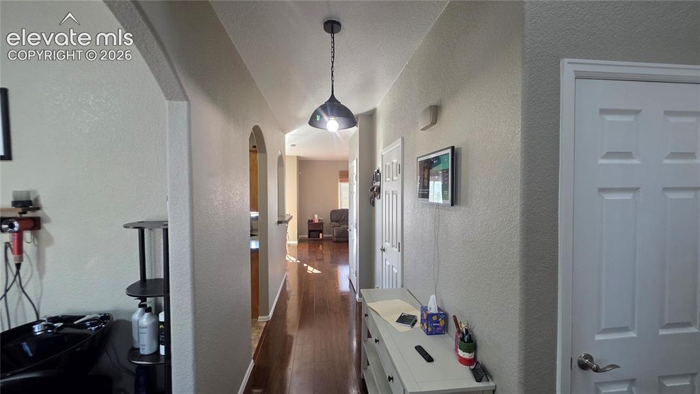 Image 7 of 35: Hallway featuring wood-finish flooring, arched doorways, and a contemporary