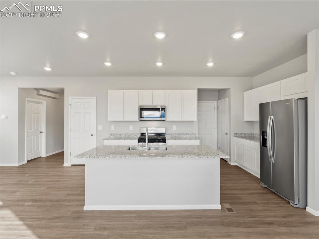 Image 2 of 25: Kitchen featuring white cabinetry, appliances with stainless steel finishes