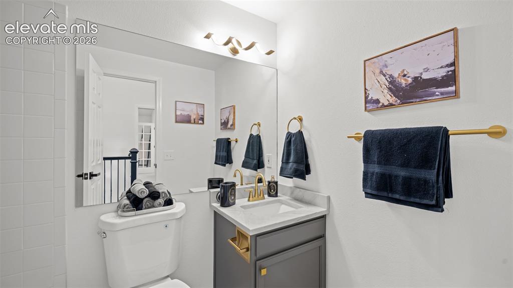 Image 17 of 46: Modern bathroom vanity featuring a rectangular sink, brass-finish faucet, a
