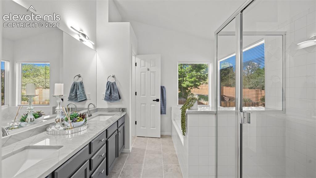 Image 22 of 46: Spacious bathroom featuring a dual vanity with light-toned countertops, a f