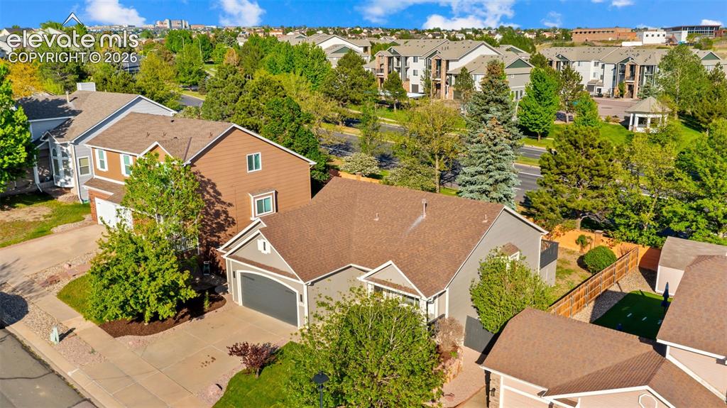 Image 37 of 46: Suburban property featuring a gray exterior, attached two-car garage, and a