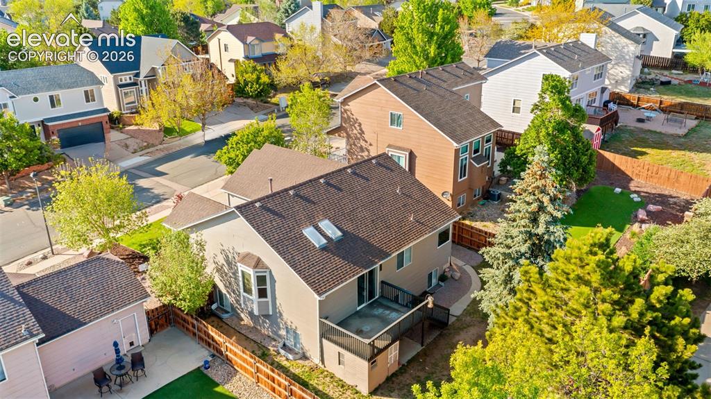 Image 44 of 46: Two-story residence featuring a bay window, a rear deck, and roof-mounted s