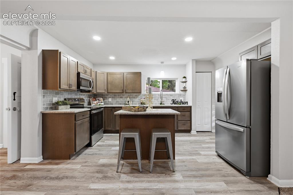Image 10 of 50: Another view of the kitchen. A pantry is included as well.