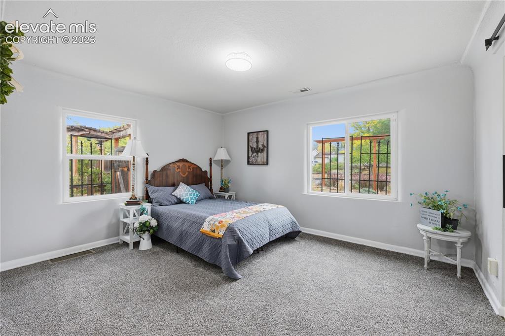 Image 16 of 50: A large primary bedroom. Everything has so much natural light.