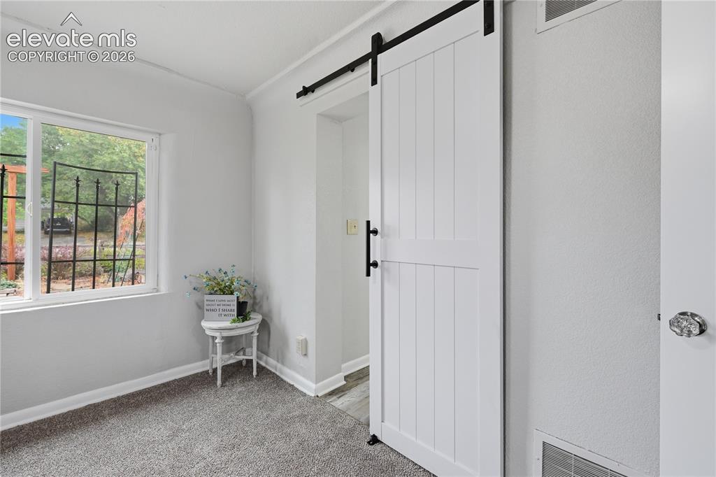 Image 19 of 50: The private barn door entrance to the bathroom.