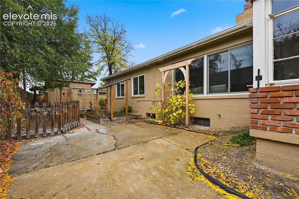 Image 40 of 50: The back of the home. The living room windows are the expansive ones that a