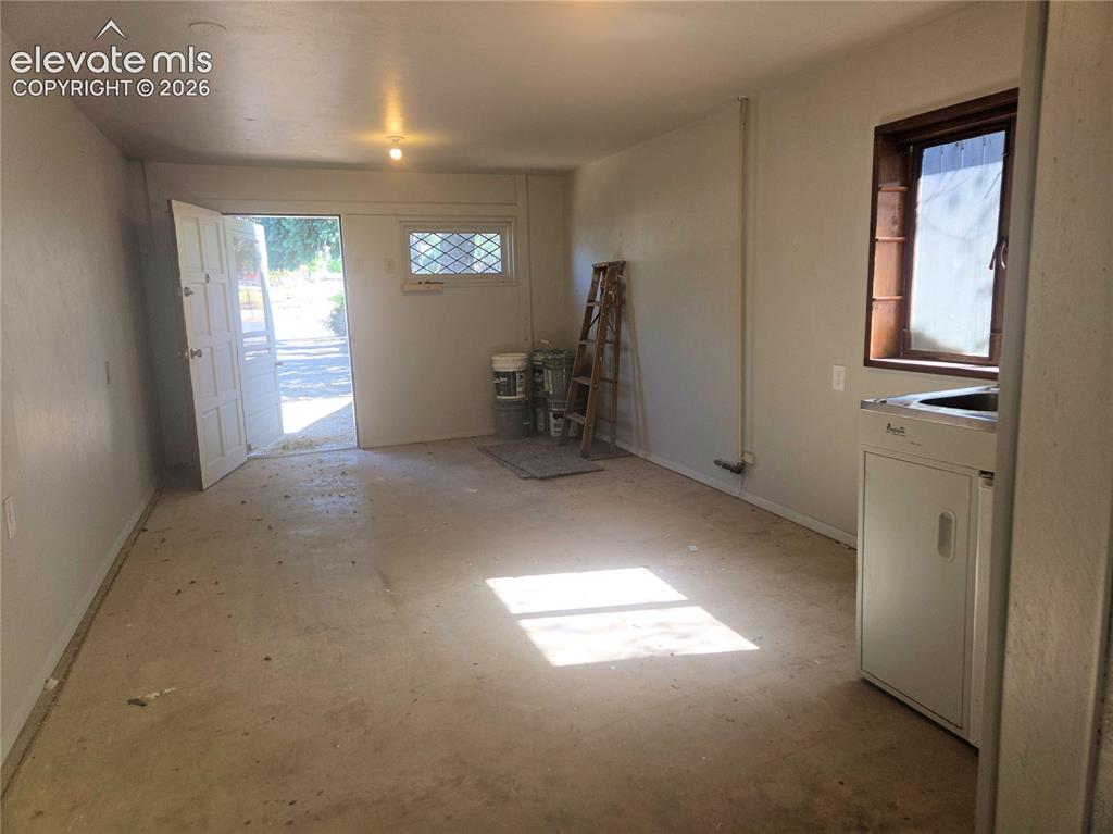 Image 50 of 50: Looking towards the front entrance to this extra space. Imagine what you ca