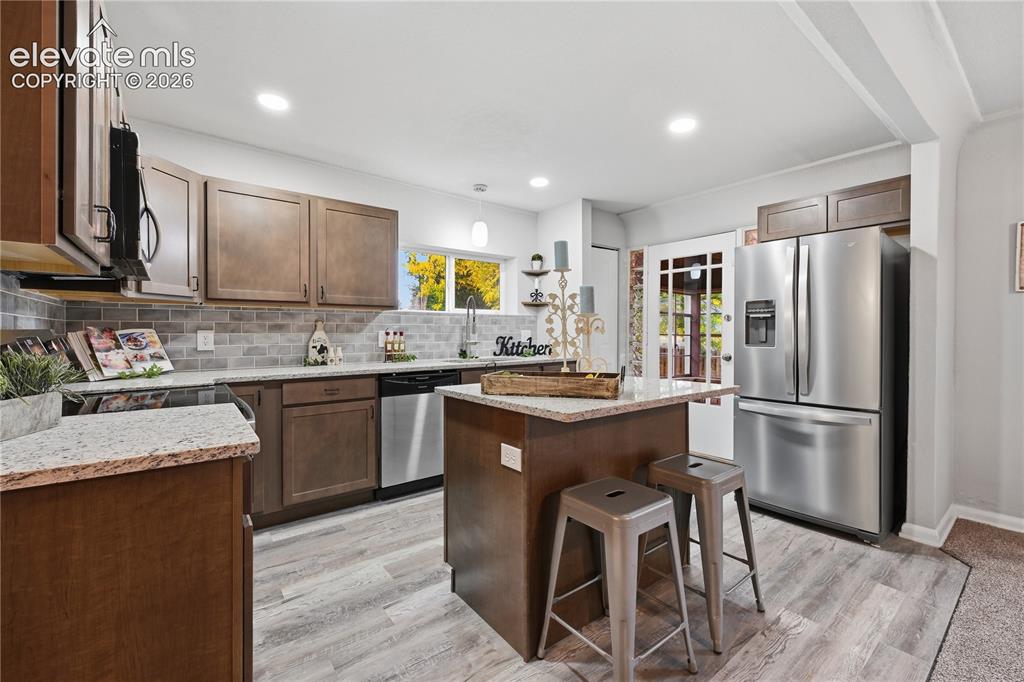 Image 9 of 50: This kitchen has access to the sun room off the back. The back door is orig