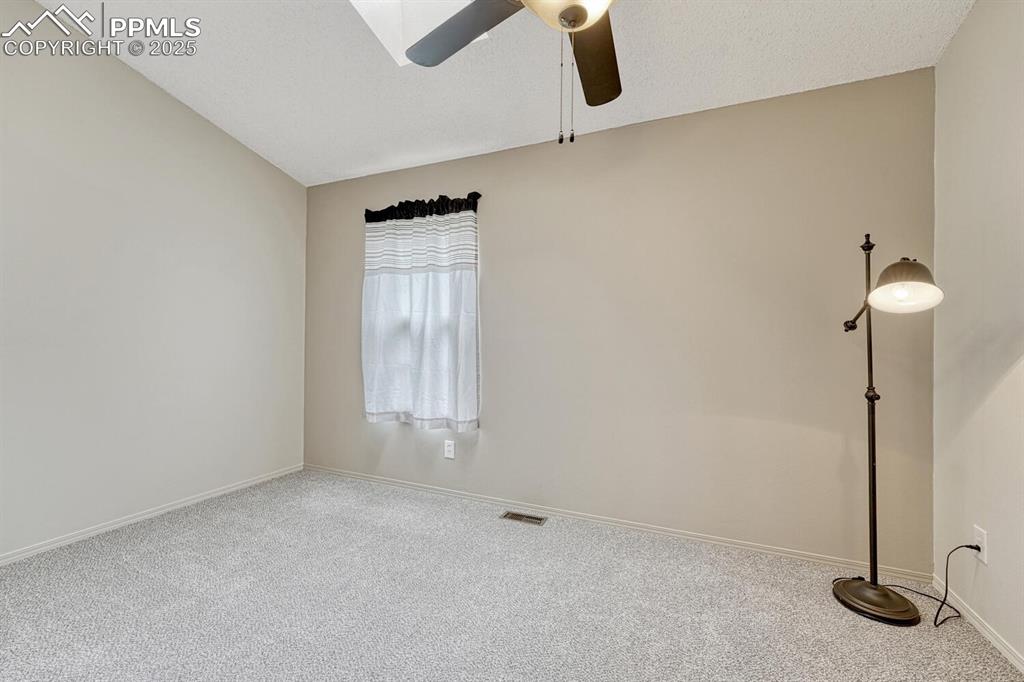 Image 19 of 50: Spare room featuring carpet flooring, a ceiling fan, and baseboards