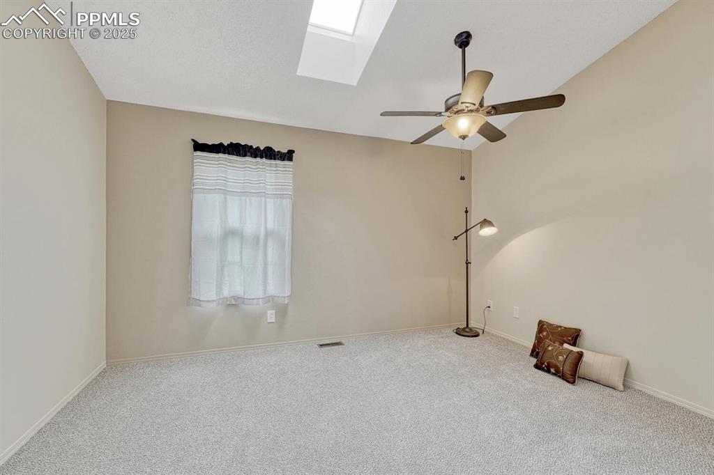 Image 20 of 50: Empty room with a skylight, carpet, ceiling fan, and plenty of natural ligh