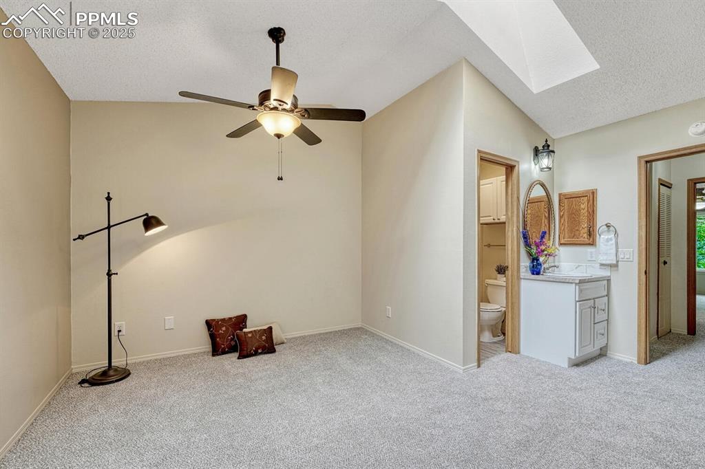 Image 21 of 50: Primary bedroom features vaulted celing, skylight, and attached full bathro