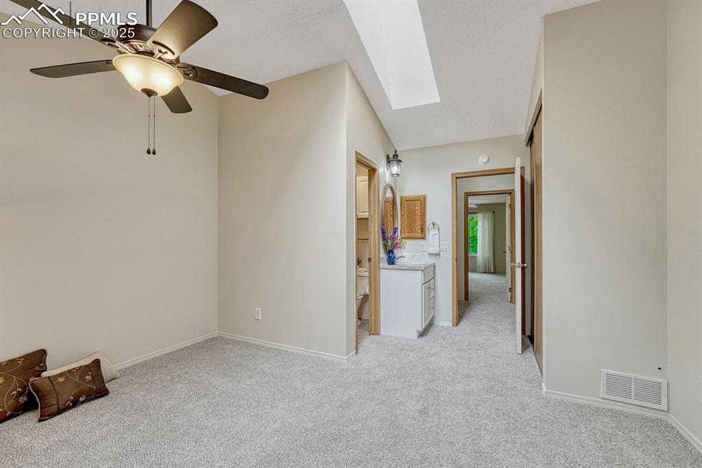 Image 22 of 50: Unfurnished bedroom featuring light colored carpet, a skylight, baseboards,