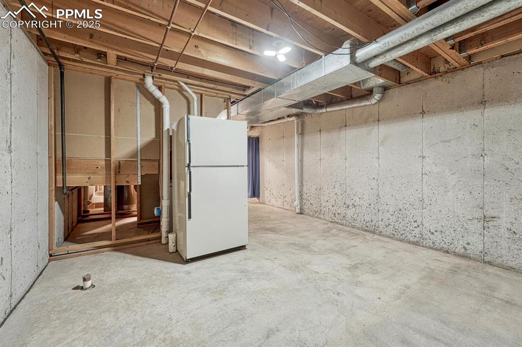 Image 35 of 50: Unfinished below grade area featuring freestanding refrigerator