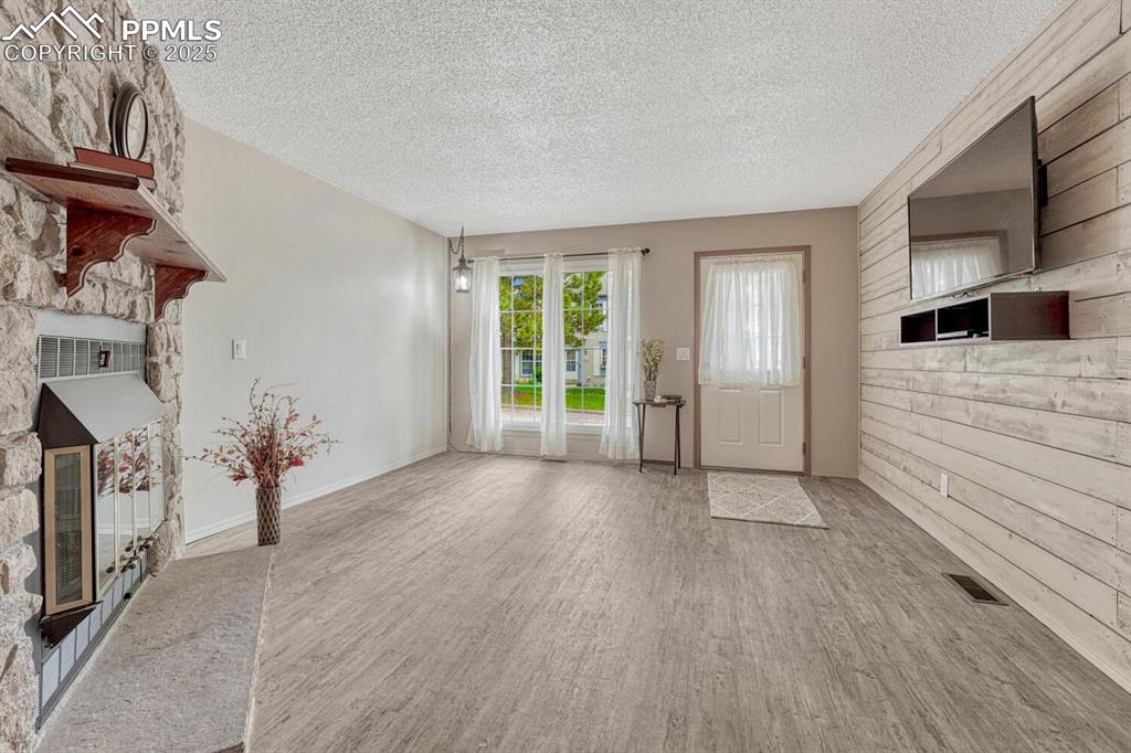 Image 4 of 50: Living room with fireplace and accent wall