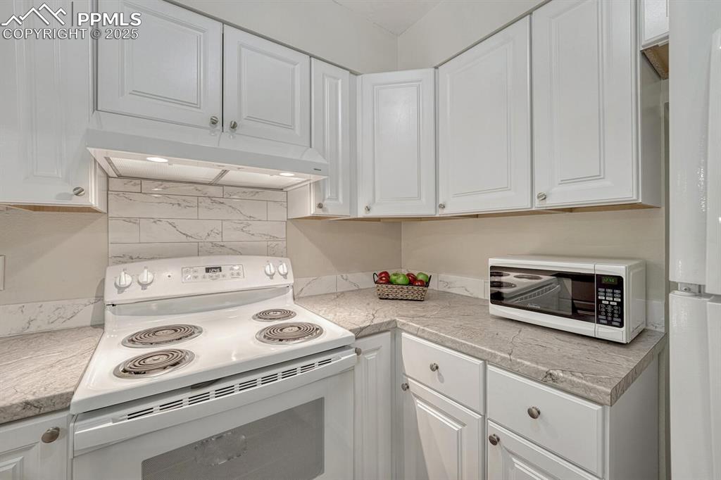 Image 9 of 50: White cabinets, marbled tile backsplash, and new counters!