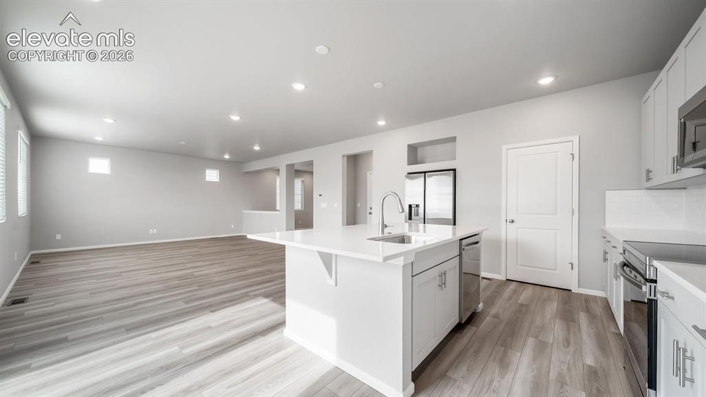Image 15 of 34: Spacious kitchen featuring a central island with a sink and breakfast bar,