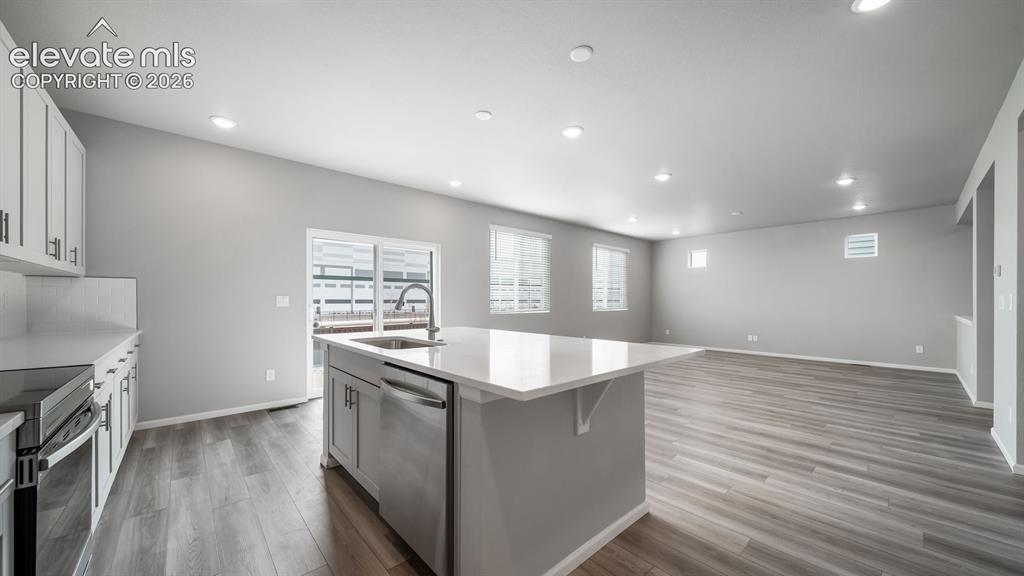 Image 16 of 34: Open concept living space featuring wood-finish flooring, recessed lighting