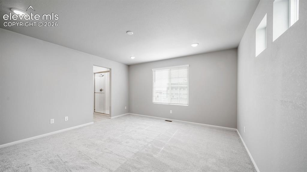 Image 20 of 34: Spacious interior room featuring light gray carpet flooring and recessed ce