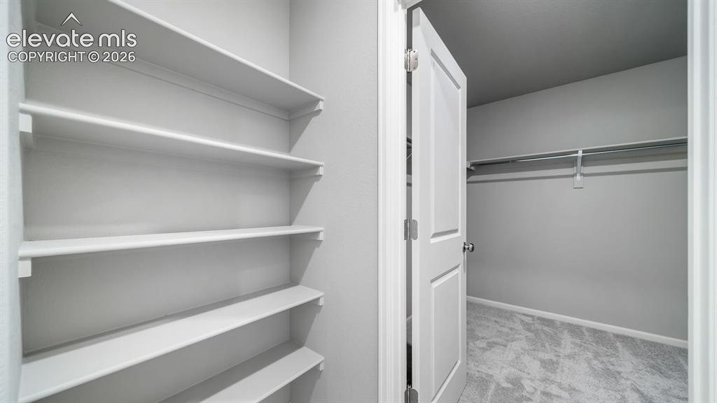 Image 24 of 34: Interior closet featuring built-in shelving, a full-height hanging rod, gra