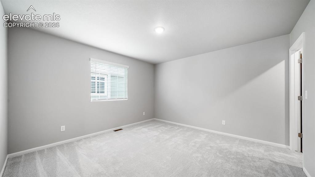 Image 26 of 34: Spacious room featuring light gray walls, light gray carpeting, white trim,