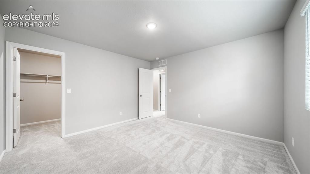 Image 27 of 34: Carpeted room featuring a window with blinds, recessed lighting, and a walk