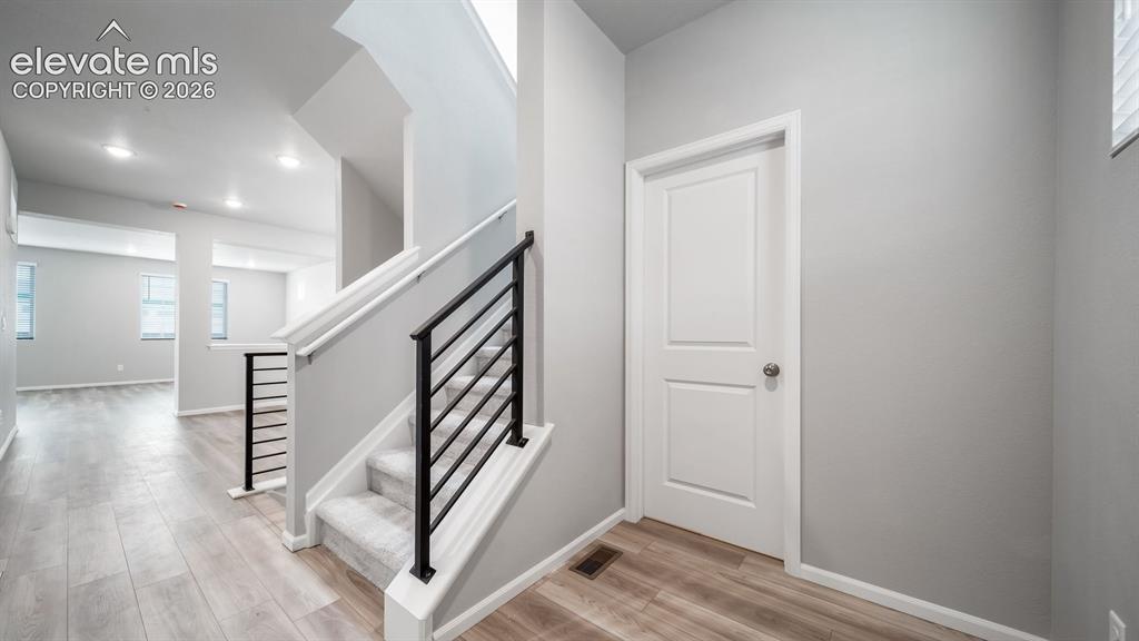 Image 3 of 34: Modern staircase with black horizontal railing and white newel posts, paire