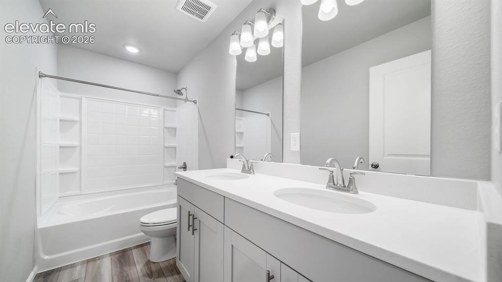 Image 30 of 34: Bathroom featuring a dual vanity with integrated sinks and a large mirror