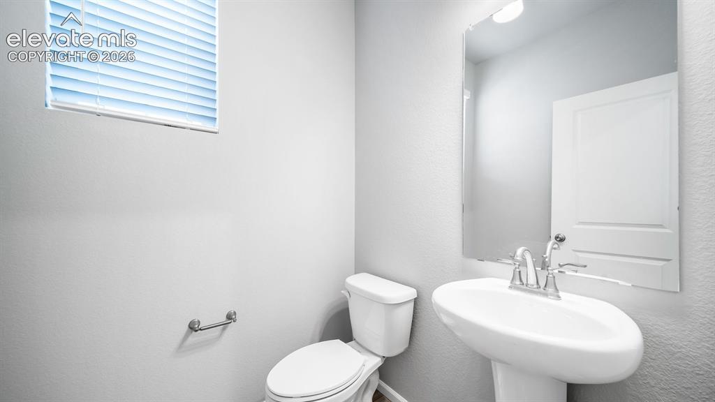 Image 4 of 34: Pedestal sink with chrome faucet, toilet, and mounted mirror
Photos of a M