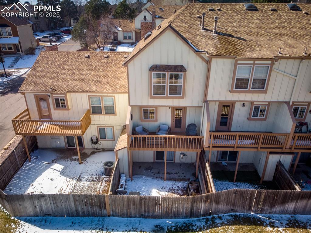 Image 41 of 47: Snow covered rear of property featuring a shingled roof, fence, board and b