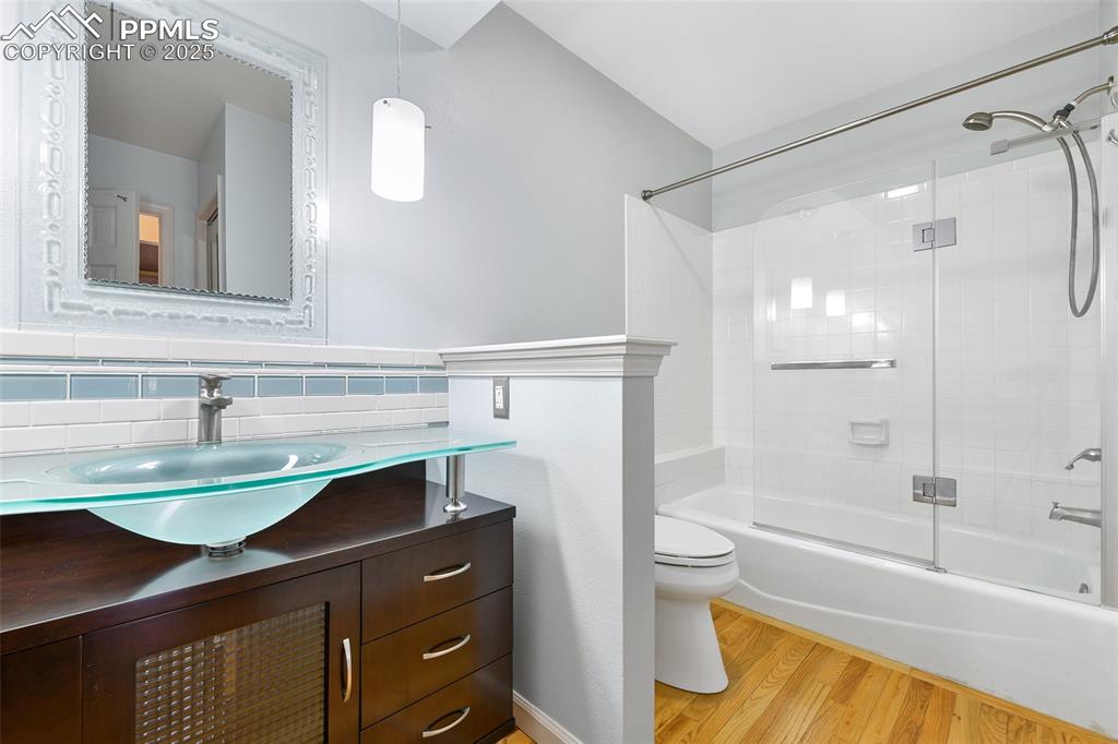 Image 11 of 25: Full bathroom with vanity, wood finished floors, shower / bath combination